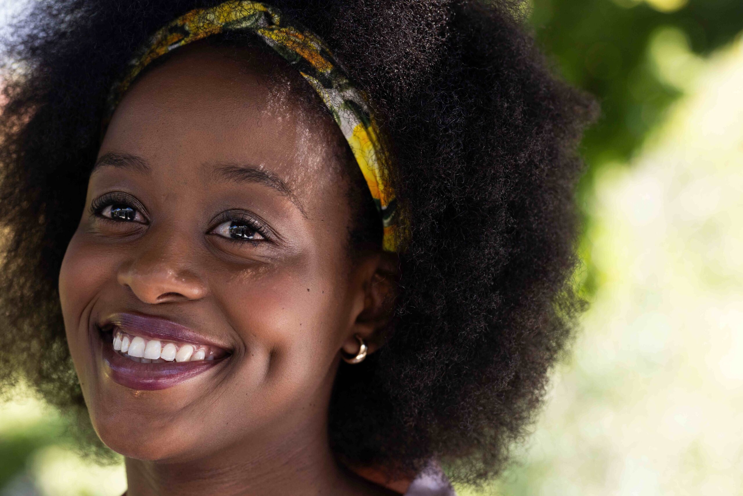 Smiling African American woman outdoors, enjoying sunny day with friends